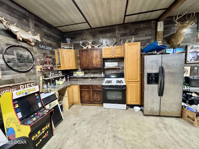 24336 S Hilltop Dr, Afton, OK 74331 - kitchen featuring concrete flooring, dark countertops, range with gas stovetop, and stainless steel fridge with ice dispenser