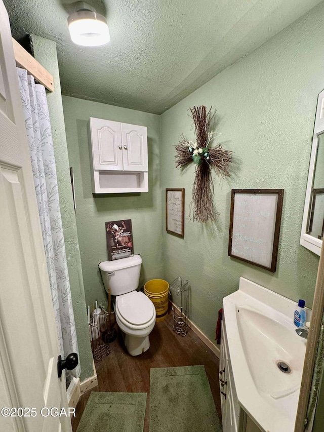 24336 S Hilltop Dr, Afton, OK 74331 - full bath featuring vanity, toilet, a textured ceiling, baseboards, and wood finished floors
