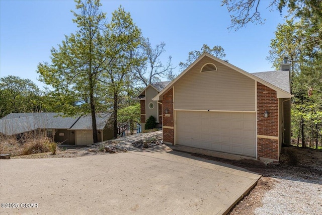 21425 Black Oak Dr, Garfield, AR 72732 - view of front of home featuring brick siding, a garage, a chimney, and driveway