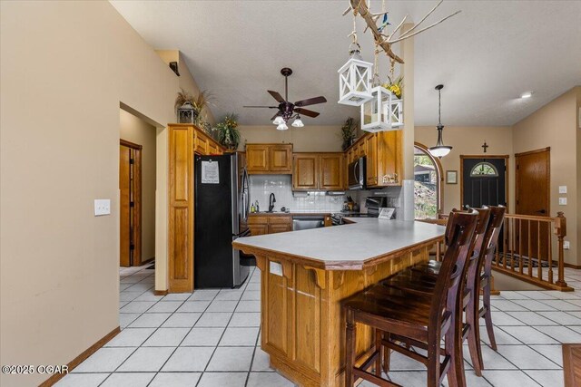 21425 Black Oak Dr, Garfield, AR 72732 - kitchen with stainless steel appliances, ceiling fan, a peninsula, tasteful backsplash, and brown cabinets