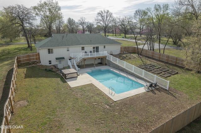 view of pool featuring a deck, a lawn, a fenced backyard, and stairs