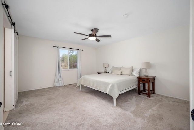 bedroom with carpet floors, a barn door, a ceiling fan, and baseboards