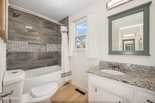 full bathroom featuring shower / bath combination with curtain, toilet, wood finished floors, visible vents, and vanity
