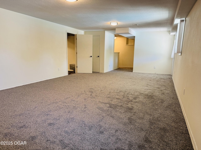 spare room with a textured ceiling, baseboards, and carpet floors