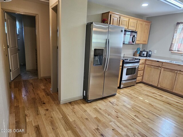 4919 State Highway 76, Anderson, MO 64831 - kitchen featuring a sink, light brown cabinetry, light wood-type flooring, light countertops, and appliances with stainless steel finishes