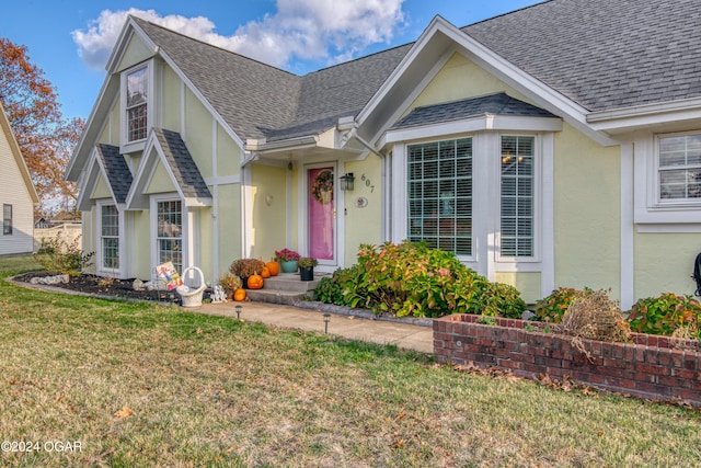 607 S Morgan Ct, Joplin, MO 64801 - view of front of house with a shingled roof, a front yard, and stucco siding