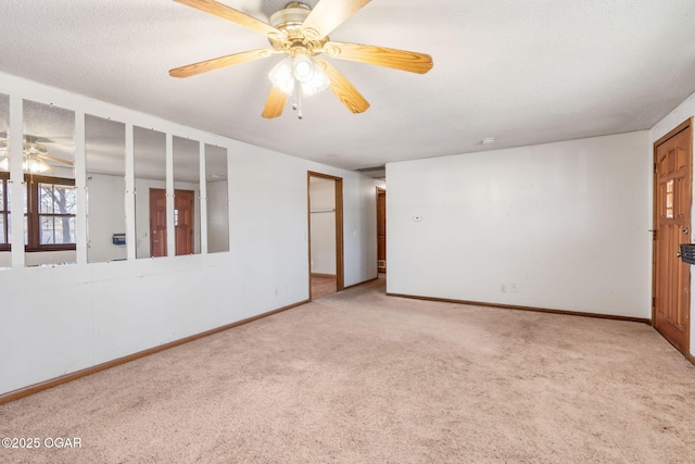 carpeted empty room with a ceiling fan and baseboards