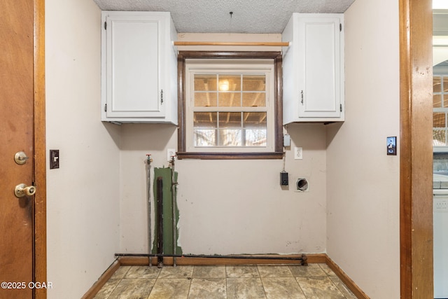 clothes washing area with electric dryer hookup, baseboards, and cabinet space
