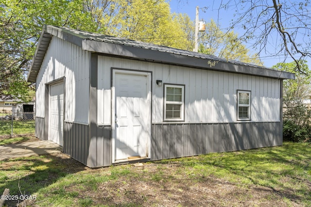 view of outdoor structure featuring fence and an outbuilding