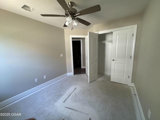 unfurnished bedroom with baseboards, concrete flooring, ceiling fan, and a closet