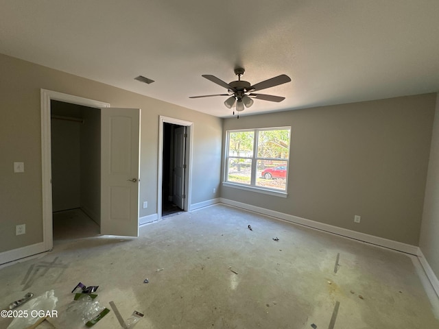 unfurnished bedroom featuring a walk in closet, ceiling fan, baseboards, and visible vents