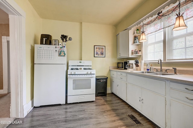 kitchen featuring visible vents, open shelves, a sink, light countertops, and white appliances