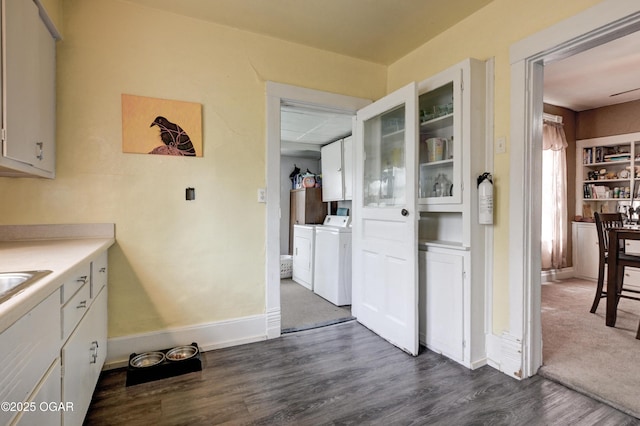 kitchen featuring washer and dryer, white cabinetry, baseboards, and dark wood finished floors