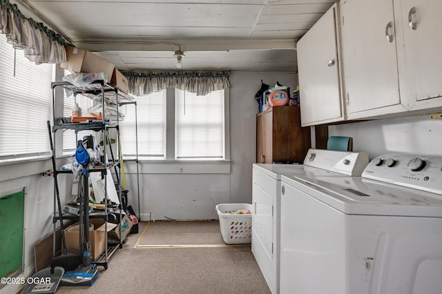 laundry room featuring washer and dryer, light carpet, and cabinet space