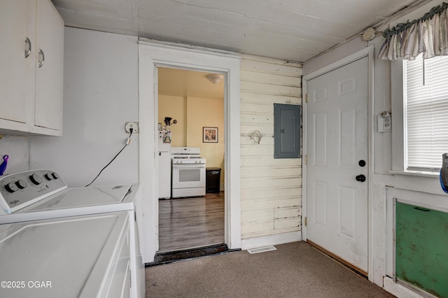 washroom featuring visible vents, wooden walls, washer and clothes dryer, electric panel, and cabinet space