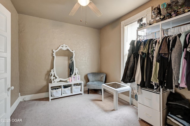 interior space with carpet floors, baseboards, and ceiling fan
