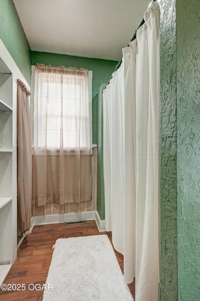 bathroom featuring a textured wall and wood finished floors