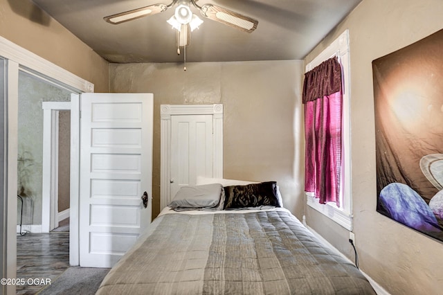 bedroom with baseboards, a ceiling fan, and wood finished floors