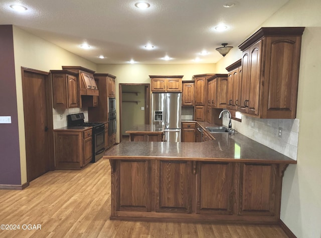 305 E Maple St, Liberal, MO 64762 - kitchen featuring gas stove, dark countertops, a sink, stainless steel refrigerator with ice dispenser, and a peninsula