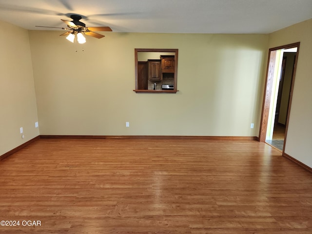 305 E Maple St, Liberal, MO 64762 - empty room featuring baseboards, ceiling fan, and light wood-style floors