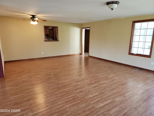 305 E Maple St, Liberal, MO 64762 - spare room featuring ceiling fan, light wood finished floors, and baseboards