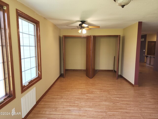 305 E Maple St, Liberal, MO 64762 - hall featuring baseboards, visible vents, and light wood-style flooring