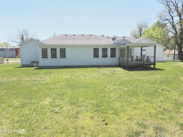 305 E Maple St, Liberal, MO 64762 - back of property featuring cooling unit, roof with shingles, a deck, and a yard