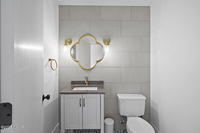 bathroom featuring tile walls, toilet, and vanity