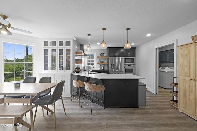 kitchen featuring appliances with stainless steel finishes, light countertops, a breakfast bar area, a peninsula, and ceiling fan