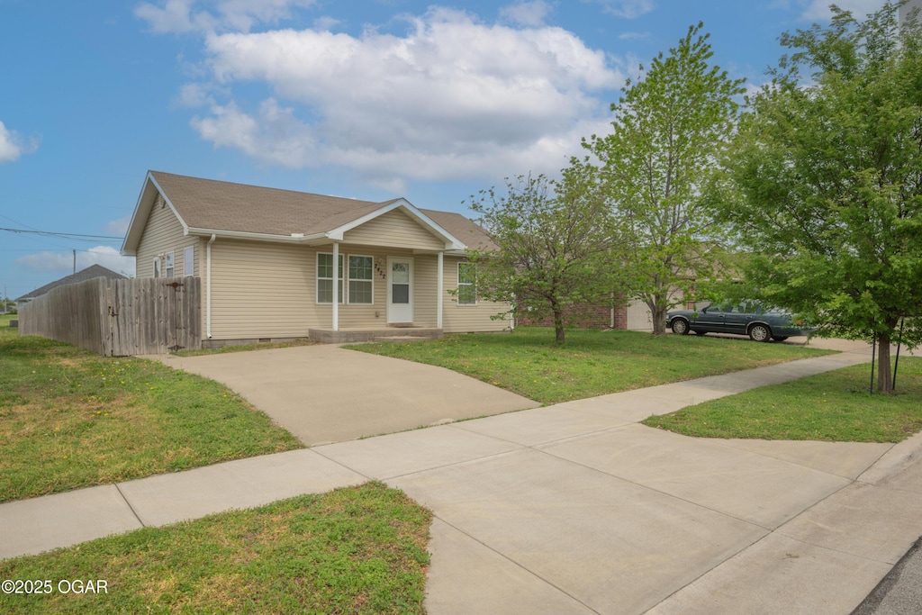 view of front of house with fence, a front yard, and concrete driveway