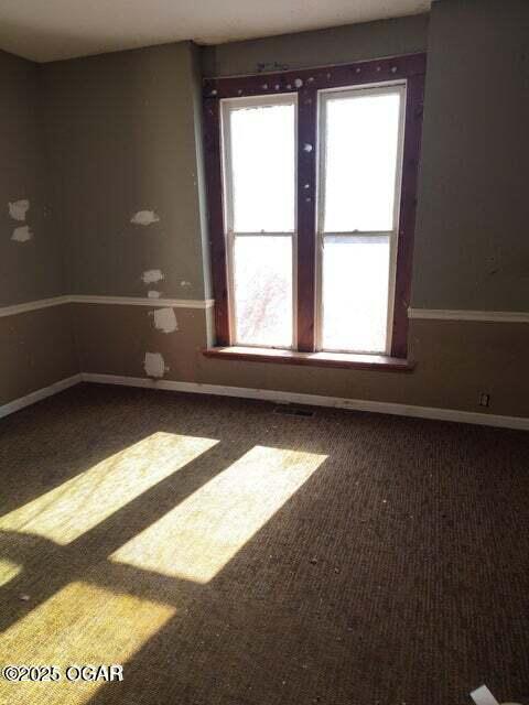 carpeted spare room with baseboards