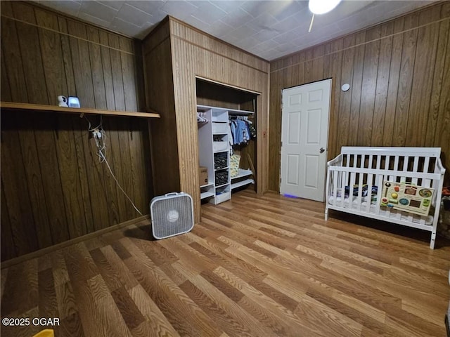 105 S Elm St, Mulberry, KS 66756 - bedroom featuring a closet, wood walls, and wood finished floors