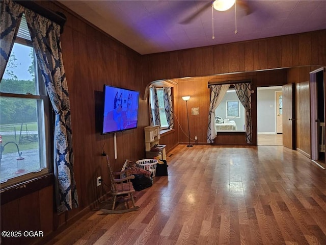 105 S Elm St, Mulberry, KS 66756 - unfurnished living room with ceiling fan, wood walls, and wood finished floors