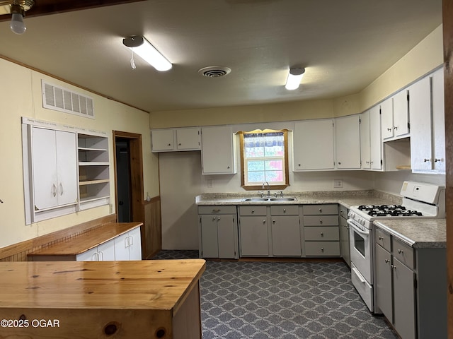 110 E Russell St, Goodman, MO 64843 - kitchen with gray cabinets, white gas stove, visible vents, open shelves, and a sink