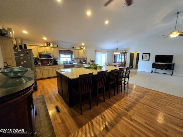 2921 E Matthews Dr, Joplin, MO 64801 - kitchen featuring a large island, appliances with stainless steel finishes, light wood finished floors, and ceiling fan with notable chandelier