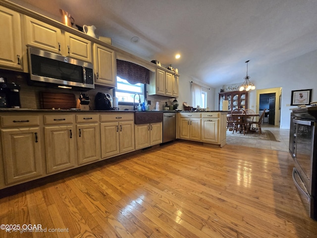 2921 E Matthews Dr, Joplin, MO 64801 - kitchen with stainless steel appliances, dark countertops, a chandelier, and light wood-style floors