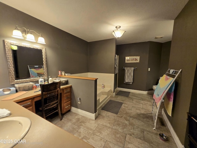 2921 E Matthews Dr, Joplin, MO 64801 - bathroom featuring a garden tub, baseboards, toilet, and vanity