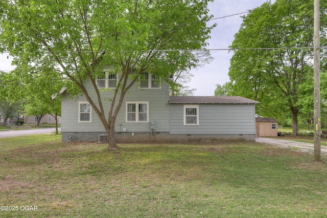 rear view of property with roof with shingles, a yard, driveway, and crawl space