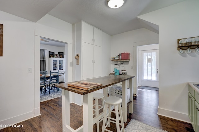kitchen featuring baseboards, dark wood finished floors, white cabinetry, and wood counters