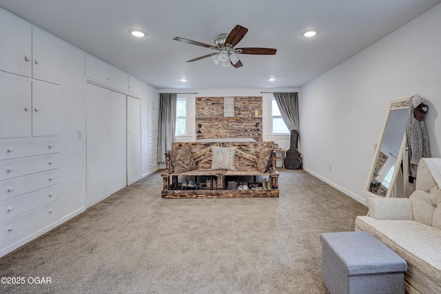 carpeted living area featuring a ceiling fan, baseboards, recessed lighting, and a healthy amount of sunlight