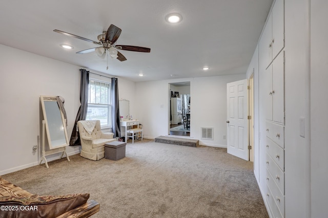 sitting room with carpet flooring, a ceiling fan, baseboards, and visible vents
