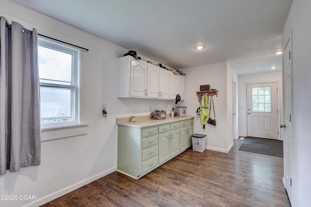 clothes washing area with dark wood-type flooring, recessed lighting, and baseboards