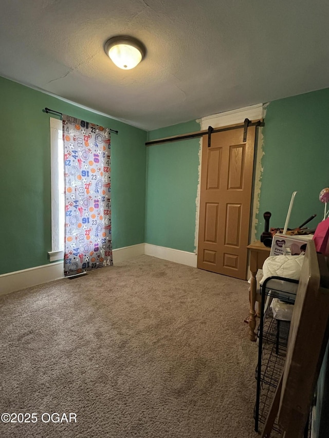 1715 S Kentucky Ave, Joplin, MO 64804 - bedroom with carpet, a textured ceiling, a barn door, and baseboards