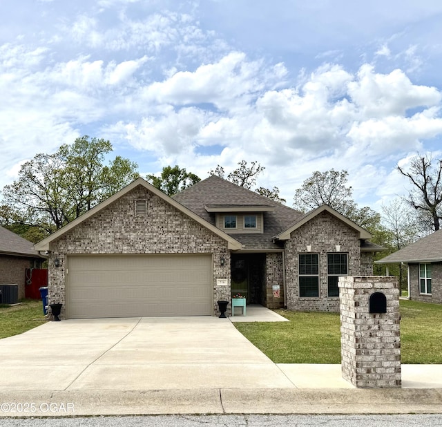 view of front of house with a front yard, driveway, roof with shingles, and a garage