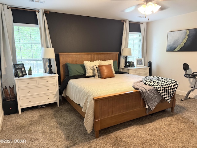carpeted bedroom with visible vents, baseboards, and multiple windows