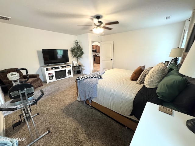 bedroom featuring arched walkways, ceiling fan, visible vents, and carpet