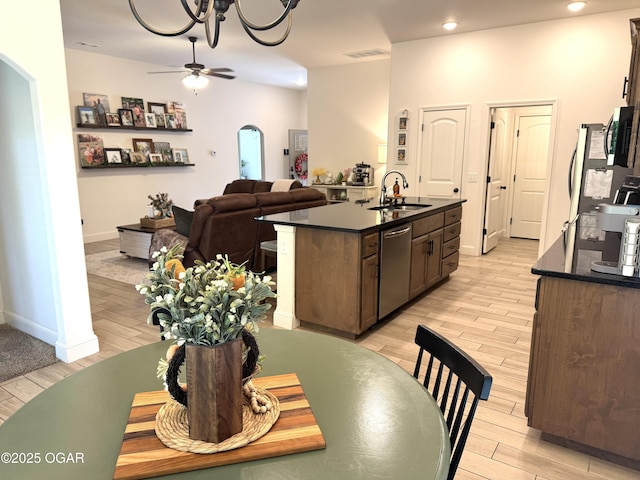 kitchen featuring a sink, dark countertops, appliances with stainless steel finishes, and arched walkways