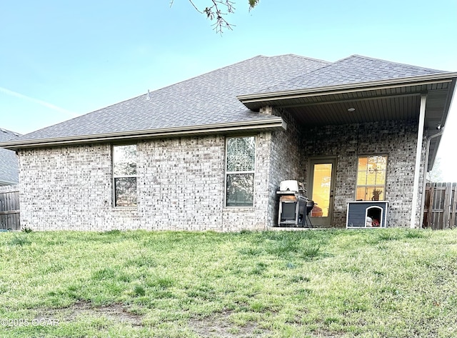716 Kara Ln, Carl Junction, MO 64834 - rear view of house with fence, a lawn, roof with shingles, and brick siding