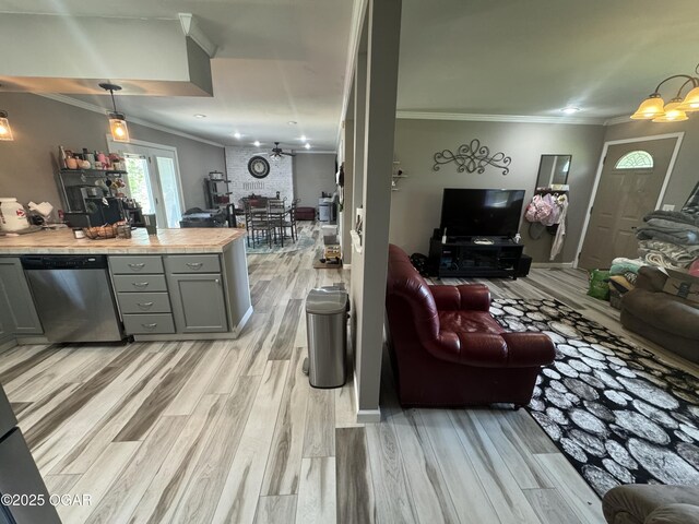 living area with an inviting chandelier, light wood finished floors, and crown molding