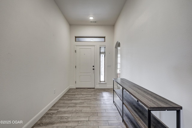 1810 Boyer Pl, Webb City, MO 64870 - foyer entrance featuring light wood-type flooring, arched walkways, and baseboards